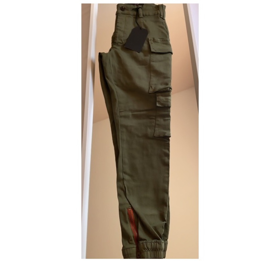 Olive green cargo pants with orange zippers.